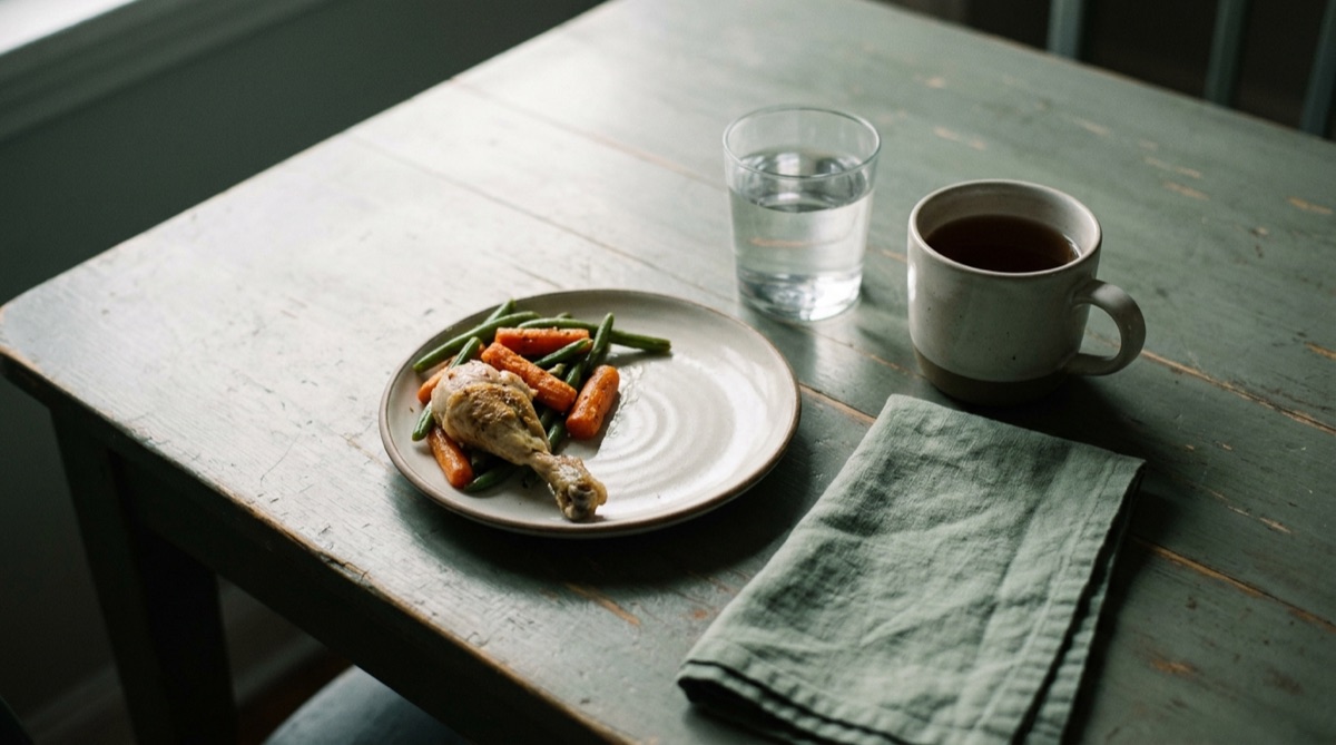 A small plate of simple home food beside water and tea